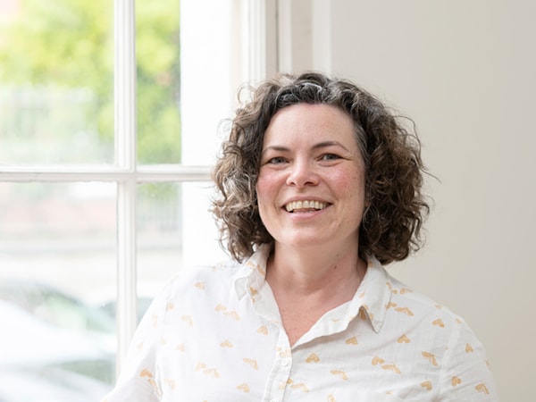 Woman in white shirt beside window